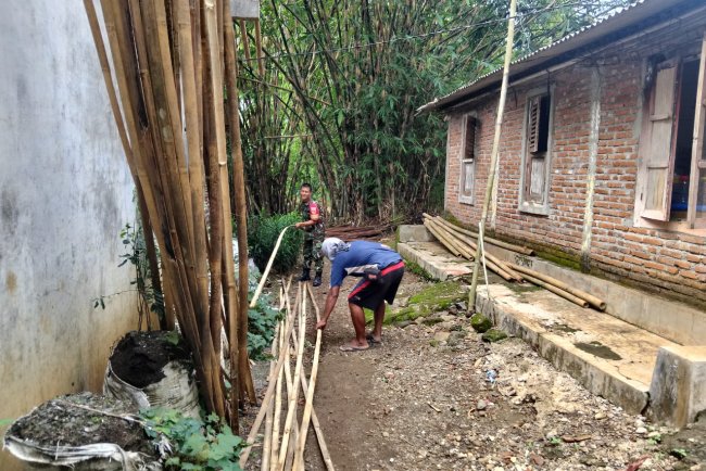 Babinsa Bantu menyiapkan bambu untuk Pemasangan Atap Rumah Warga Binaan