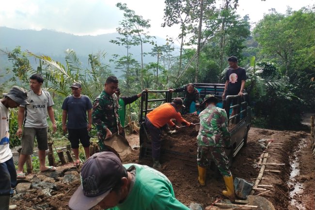 Babinsa Berbaur Dengan Warga Memperbaiki Jalan Darurat menuju Perkampungan