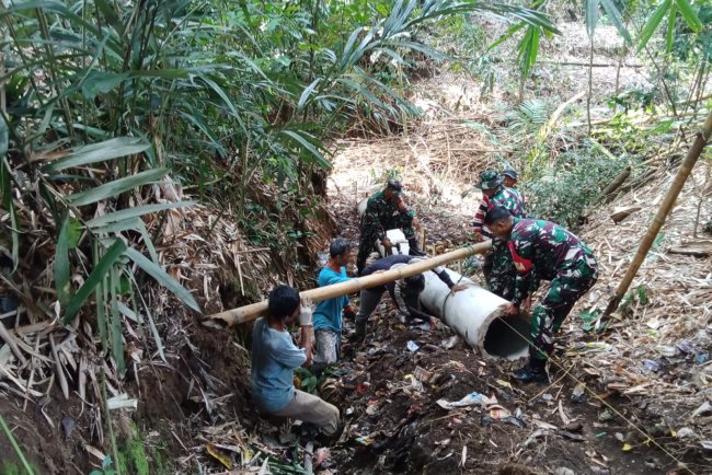Babinsa dan Warga Saling Membantu Bergotong Royong Memasang gorong gorong Di Desa Binaan