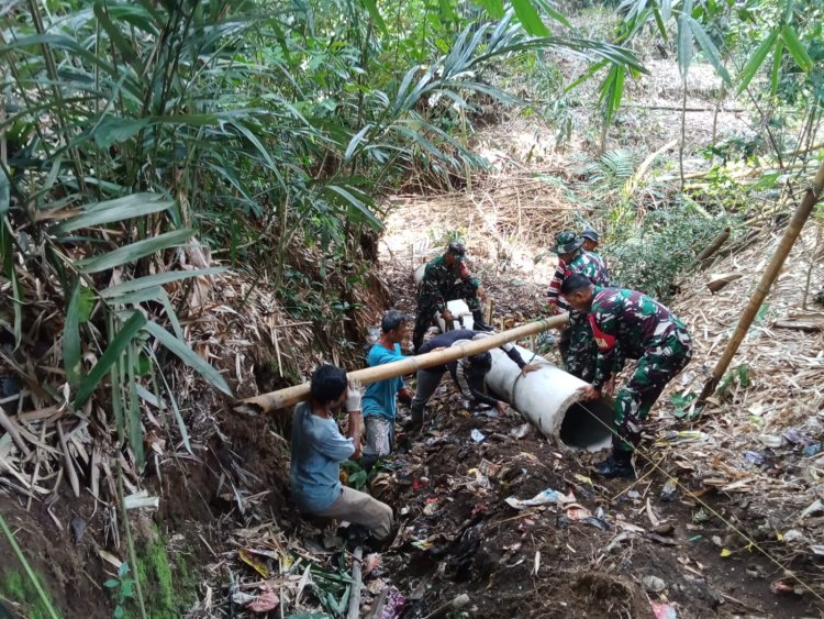 Babinsa dan Warga Saling Membantu Bergotong Royong Memasang gorong gorong Di Desa Binaan