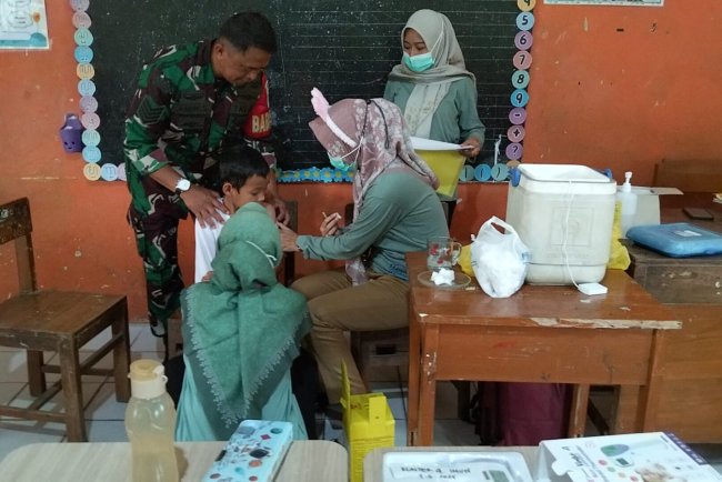 Babinsa Dampingi Kegiatan Bulan Imunisasi Anak Sekolah di Banjarmangu