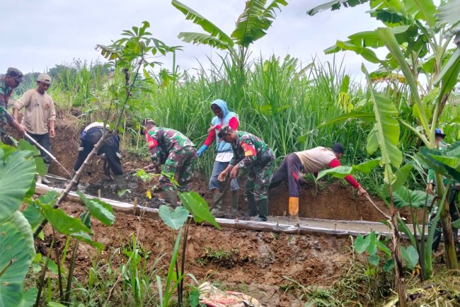 Babinsa Kerja Bakti bersama Masyarakat Pengecoran Jalan Usaha Tani