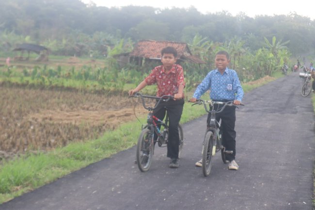 Keceriaan Anak Cikuya Saat Mencoba Gowes Sepeda diatas Aspal Jalan Baru