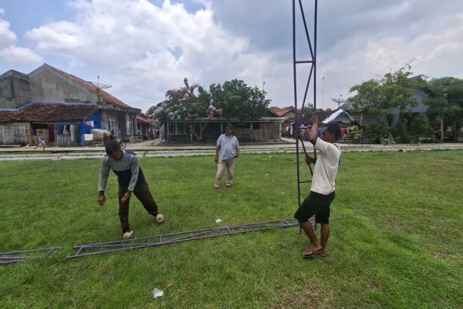 Pemuda Desa Cikuya Bahu-Membahu Siapkan Tenda Upacara di Lapangan Desa