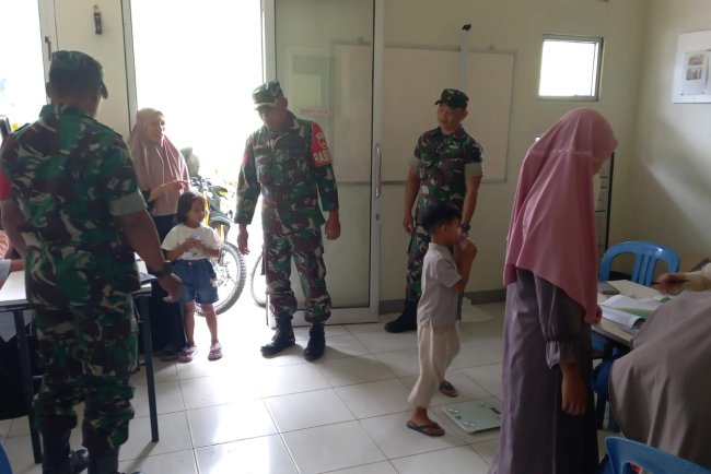 Babinsa Koramil 04/Karangkobar Bantu Bidan Desa Dampingi Giat Posyandu Balita
